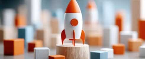 Fusée orange et blanche sur socle en bois entourée de cubes colorés