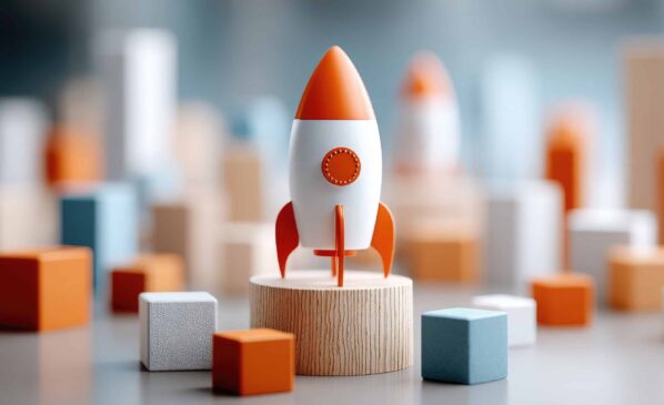 Fusée orange et blanche sur socle en bois entourée de cubes colorés